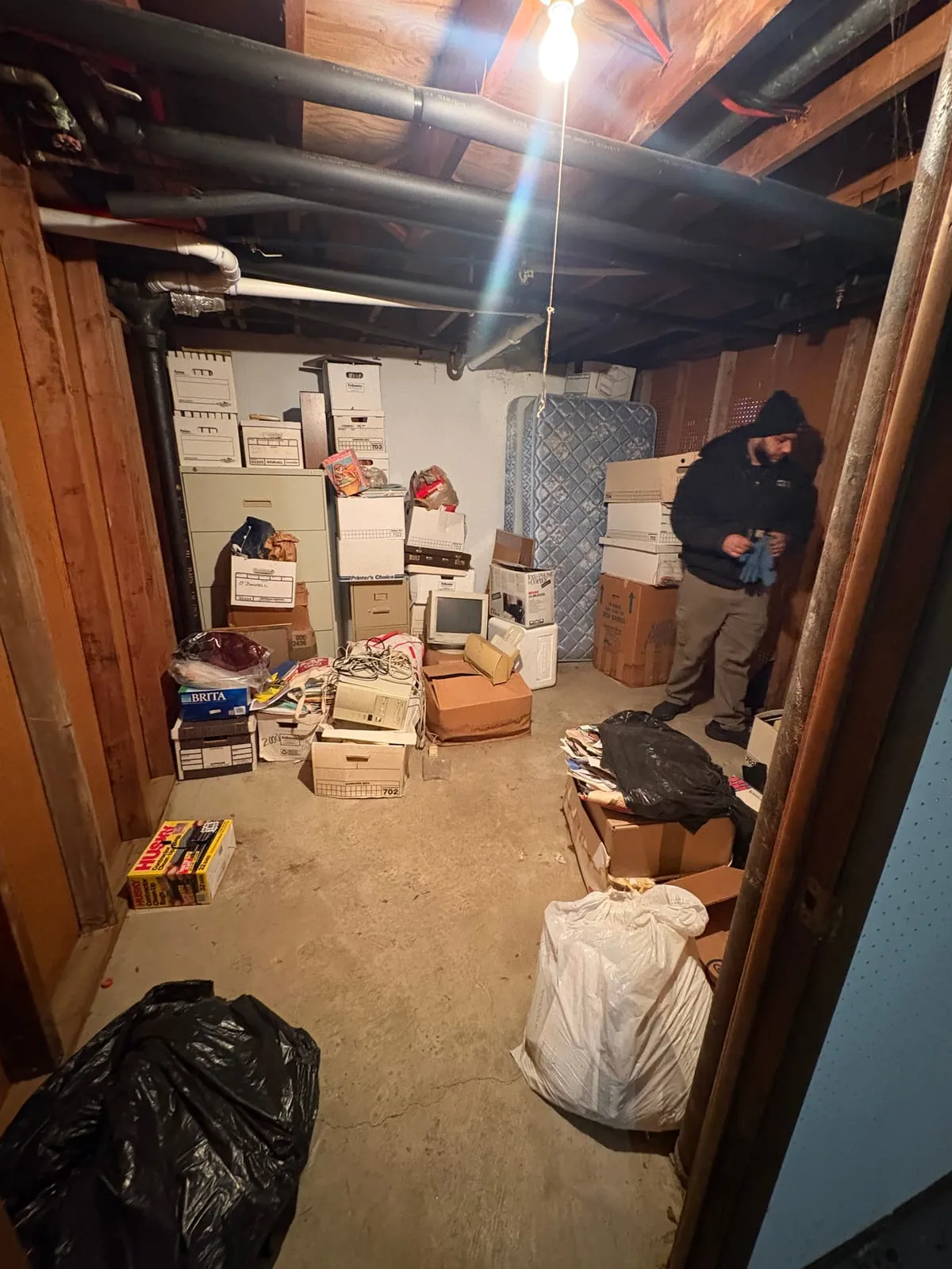 Basement room stacked with storage totes and boxes
