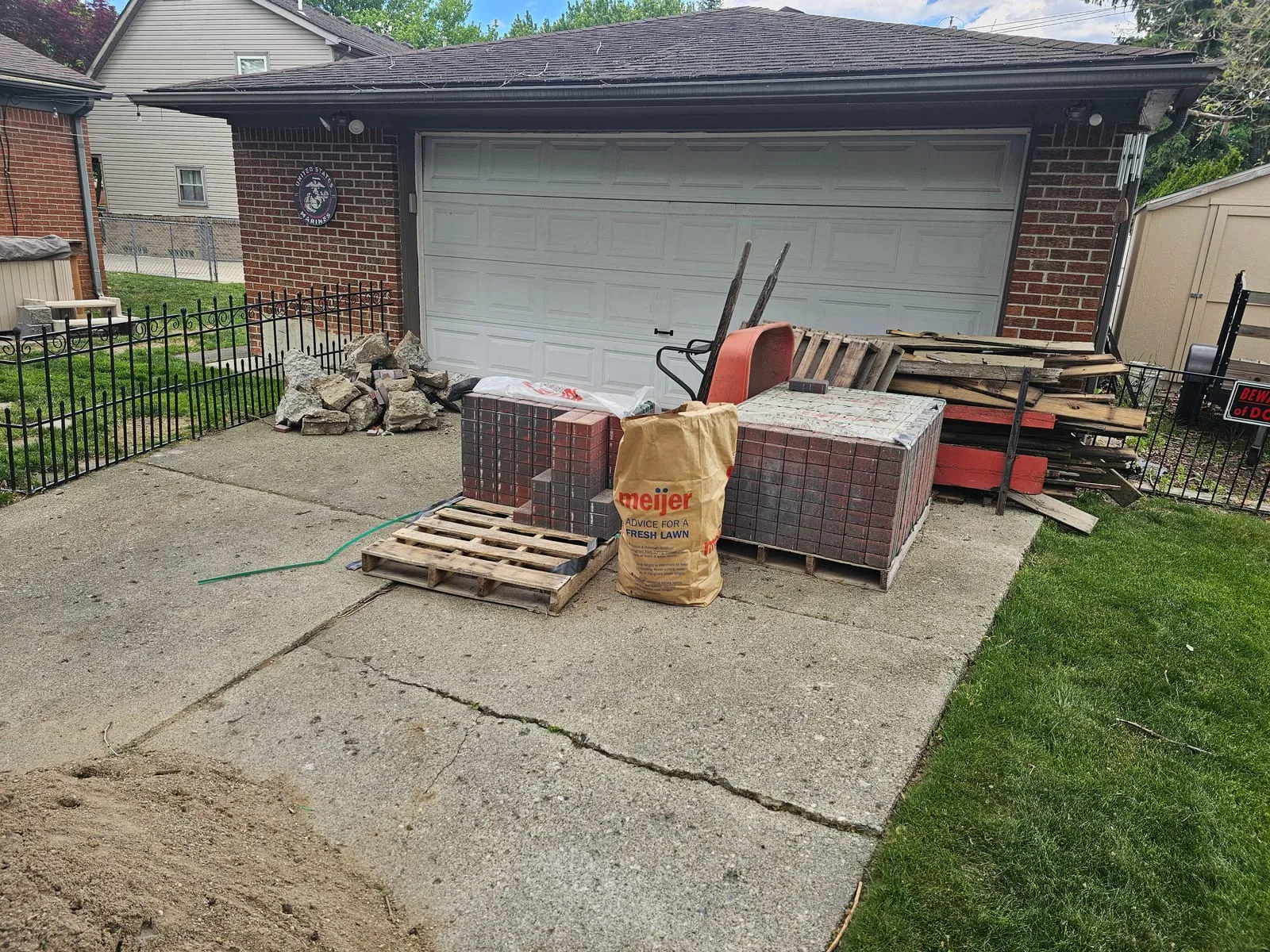 Driveway blocked by a pallet of bricks and construction materials