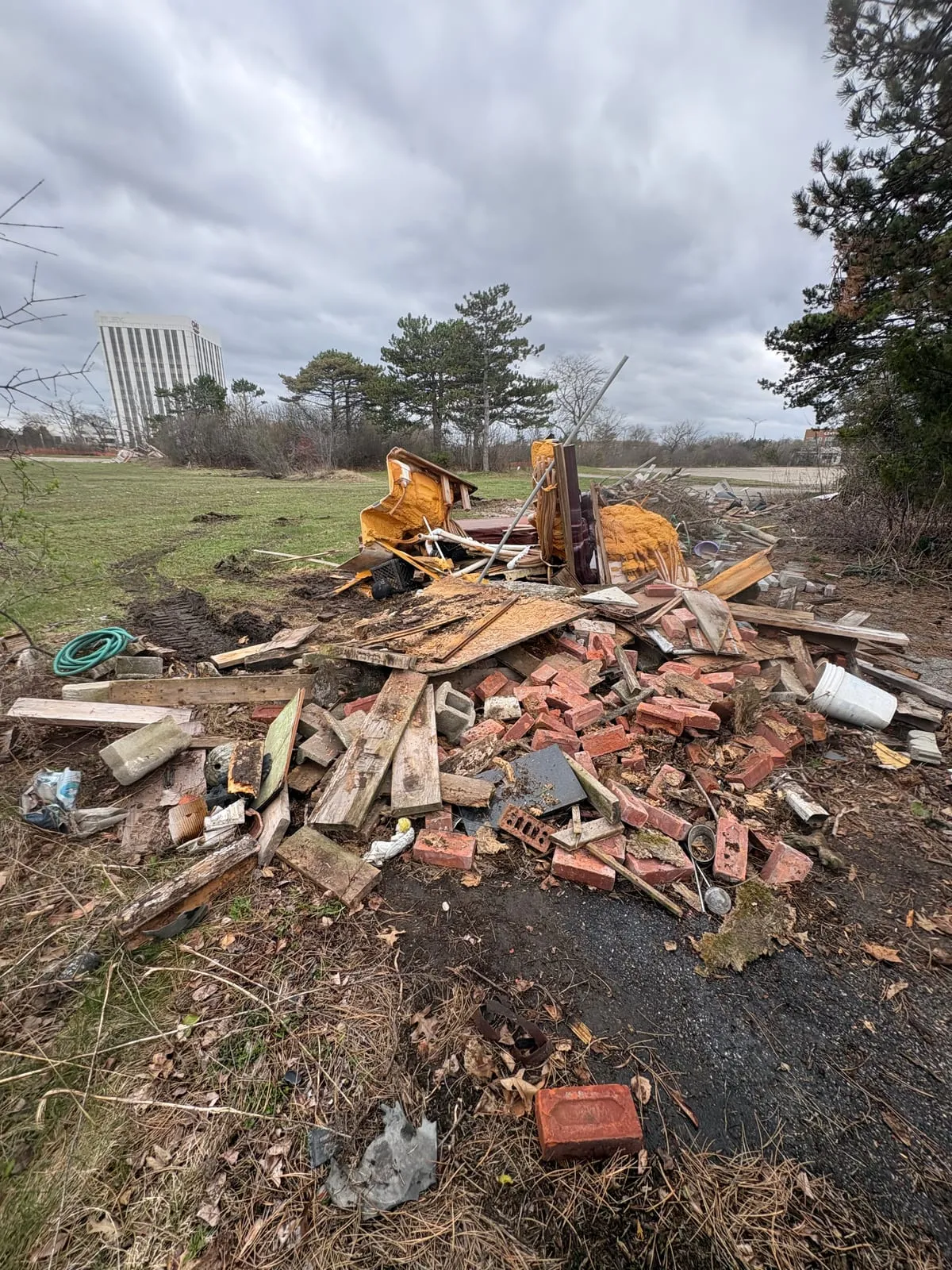 Piles of demolition lumber and scrap across an open lot