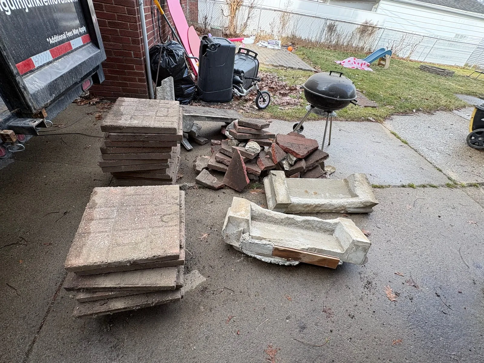 Stacked concrete pavers and rubble piled on a driveway