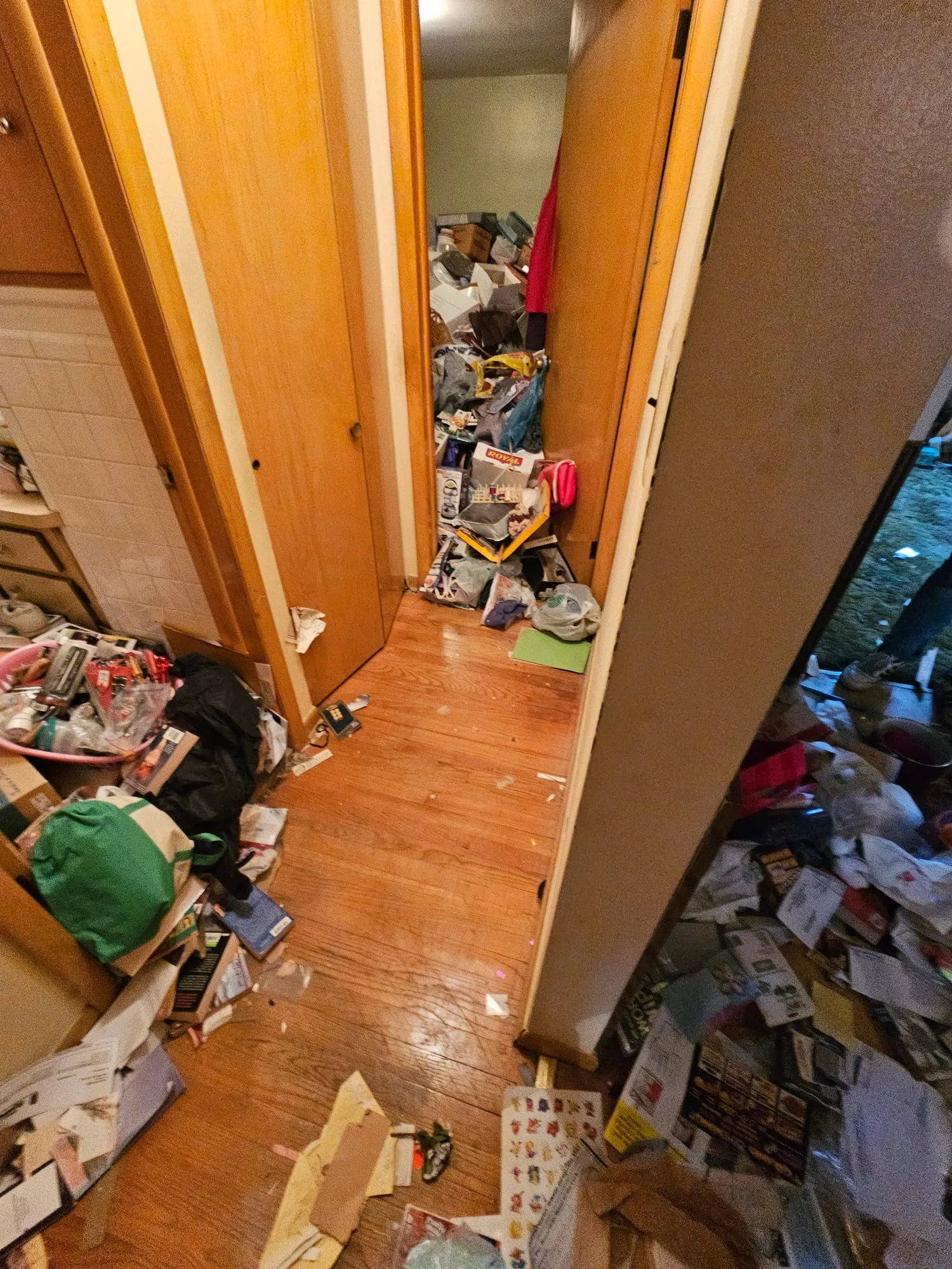 Hallway of a Metro Detroit home piled with clutter before a full property cleanout