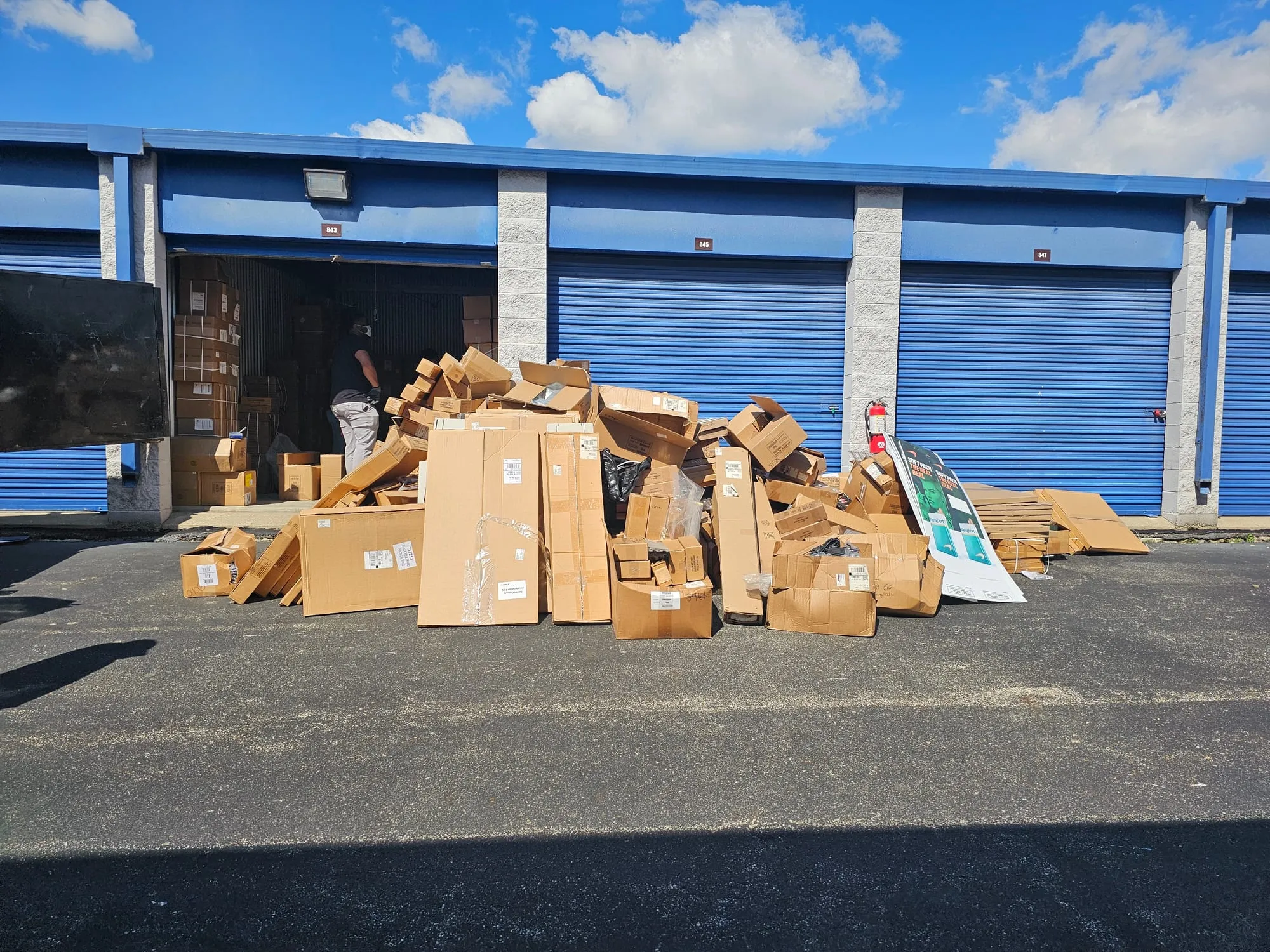 Cardboard and debris cleared from a rental storage unit onto the driveway